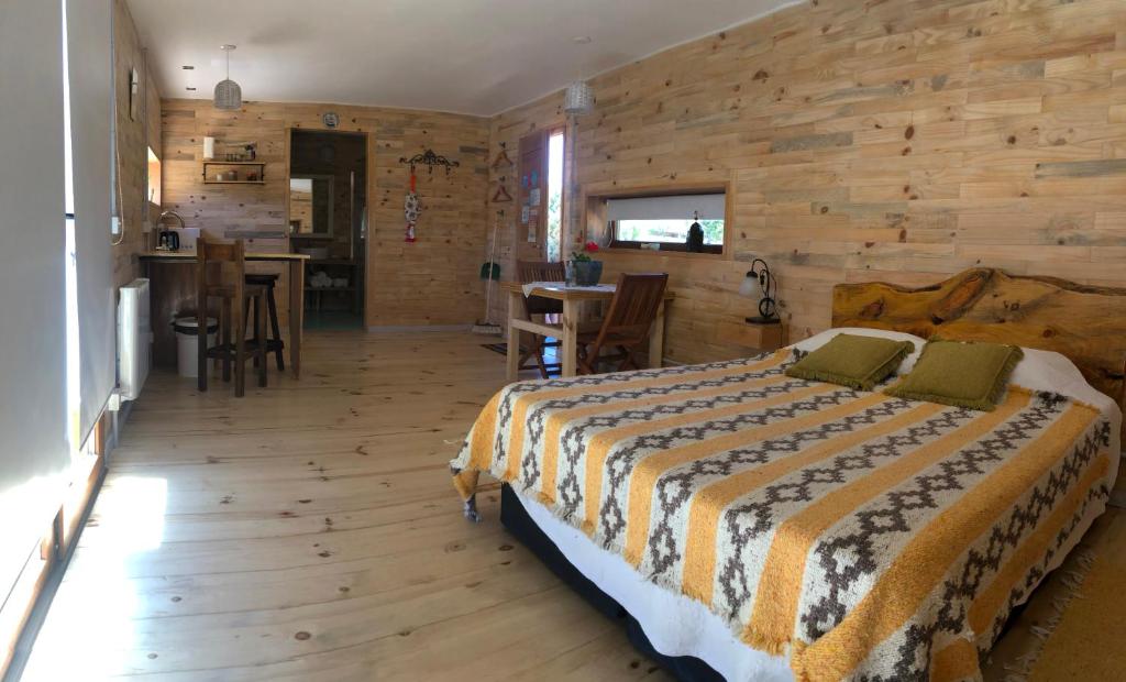 CholilaWau Purul, Cabaña 2的一间卧室设有一张床和木墙