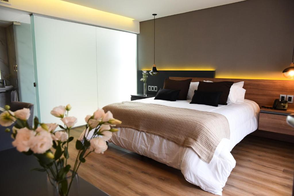 圣弗朗西斯科Hotel Soho Suites的一间卧室配有一张大床和花瓶