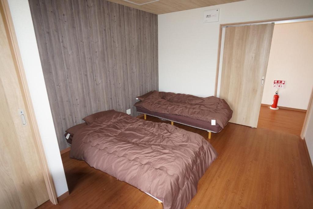 高松Guest House Ihatov - Vacation STAY 22122v的一间铺有木地板的客房,配有两张床。