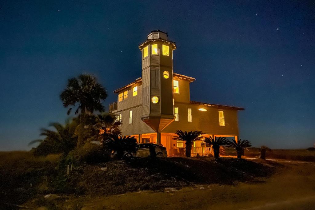 圣乔治岛Lighthouse By The Sea的一座在晚上设有钟楼的大型建筑