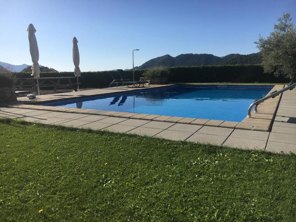 科利德纳尔戈Apartaments Cal Borda的庭院内带遮阳伞的游泳池