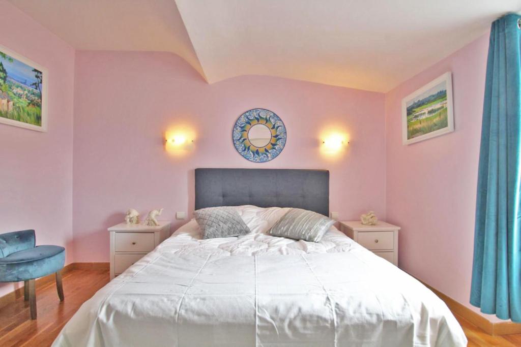 瑟堡LE NID DES MOUETTES的卧室配有一张带粉红色墙壁的大床