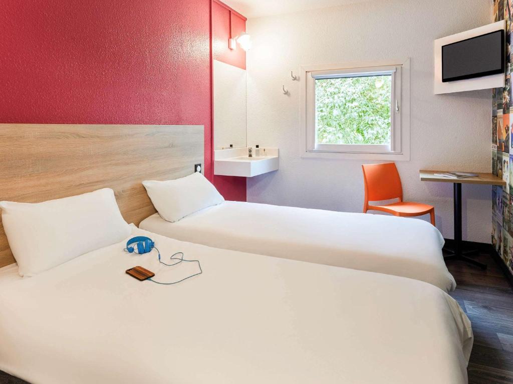 圣艾蒂安圣艾特恩酒店的酒店客房设有两张床和盥洗盆
