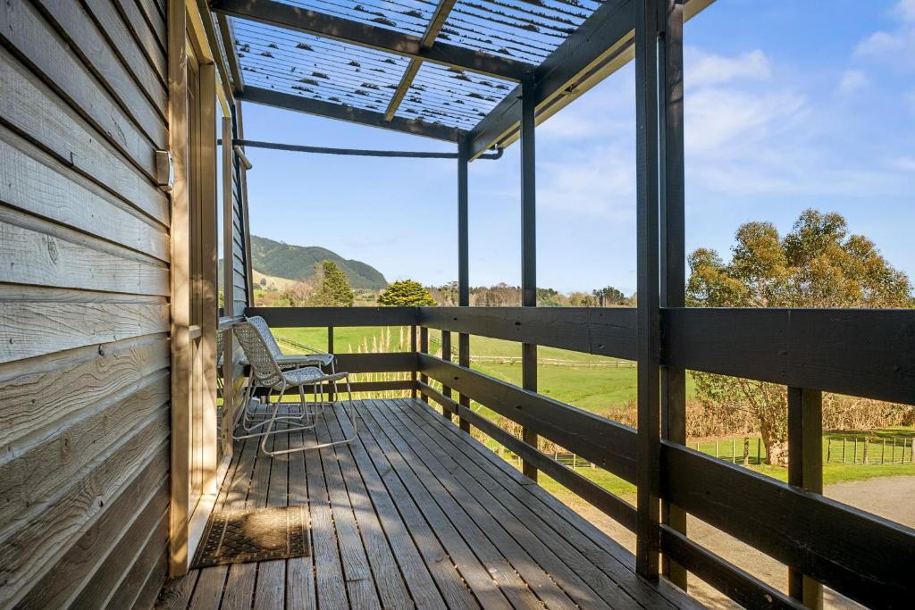 Te HoroThe Apartment - The Lodge Te Horo的一个带长凳并享有田野景色的门廊