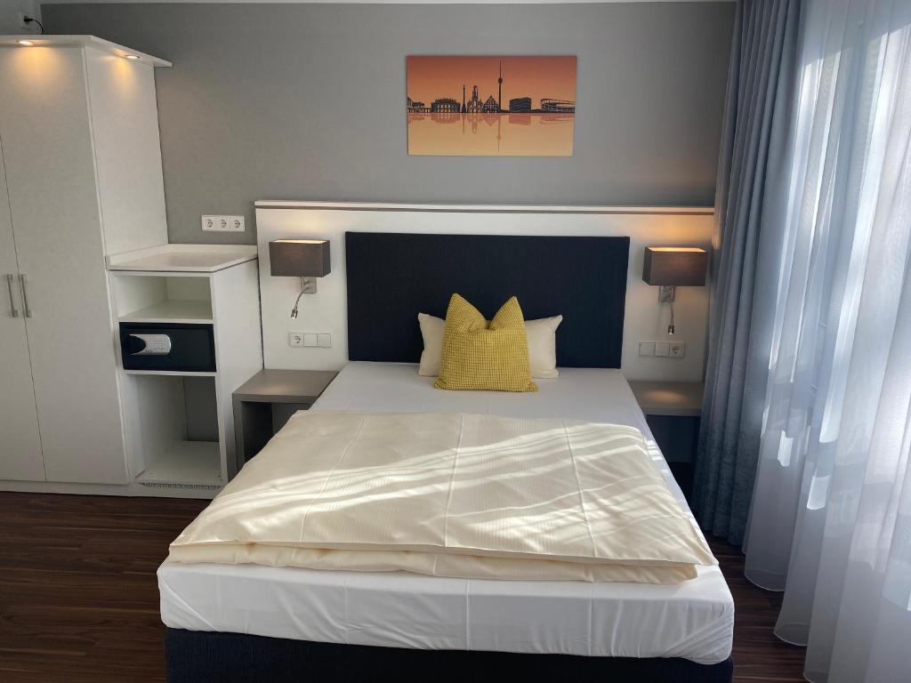 斯图加特Mirage City Hotel Stuttgart Zentrum的卧室配有一张带黄色枕头的大型白色床。