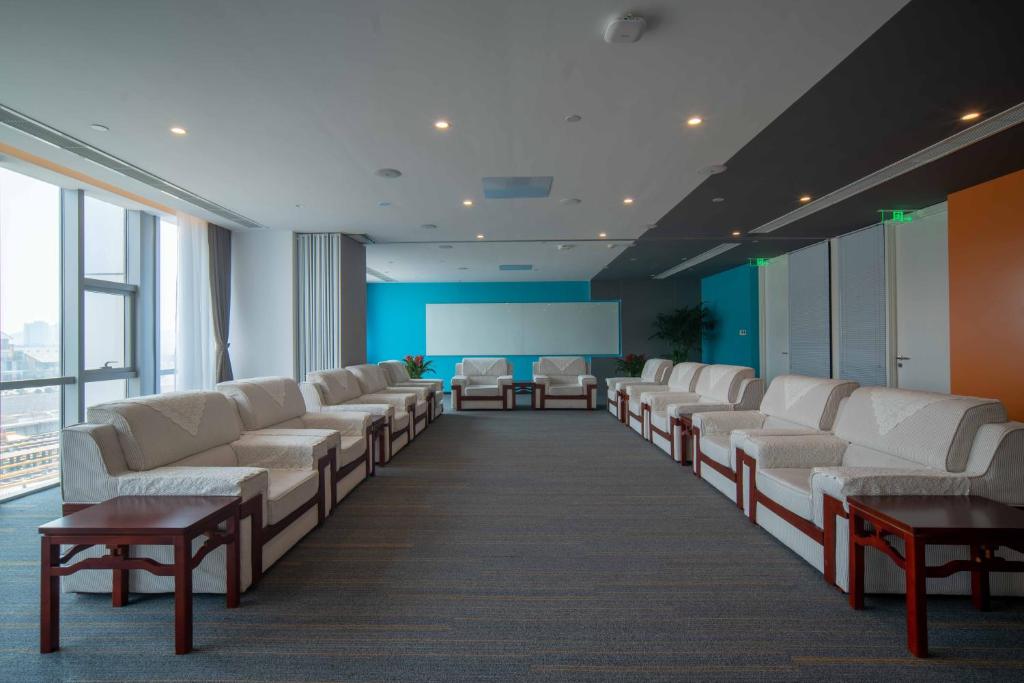 青岛青岛国际创新园智选假日酒店的一间空的等候室,配有白色的椅子和窗户