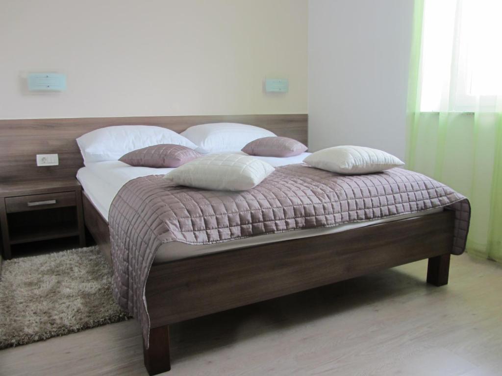 洛加泰茨托拉兹旅馆的卧室内的一张带四个枕头的床