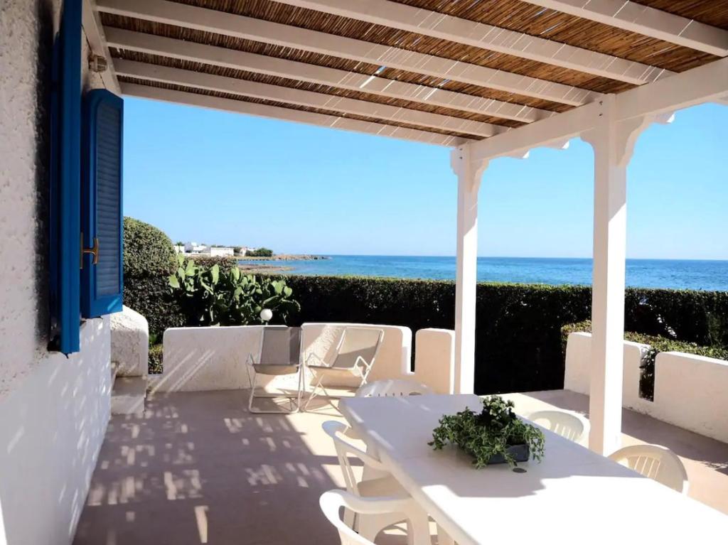 托雷苏达Villa Oltremare的海景露台上的白色桌椅