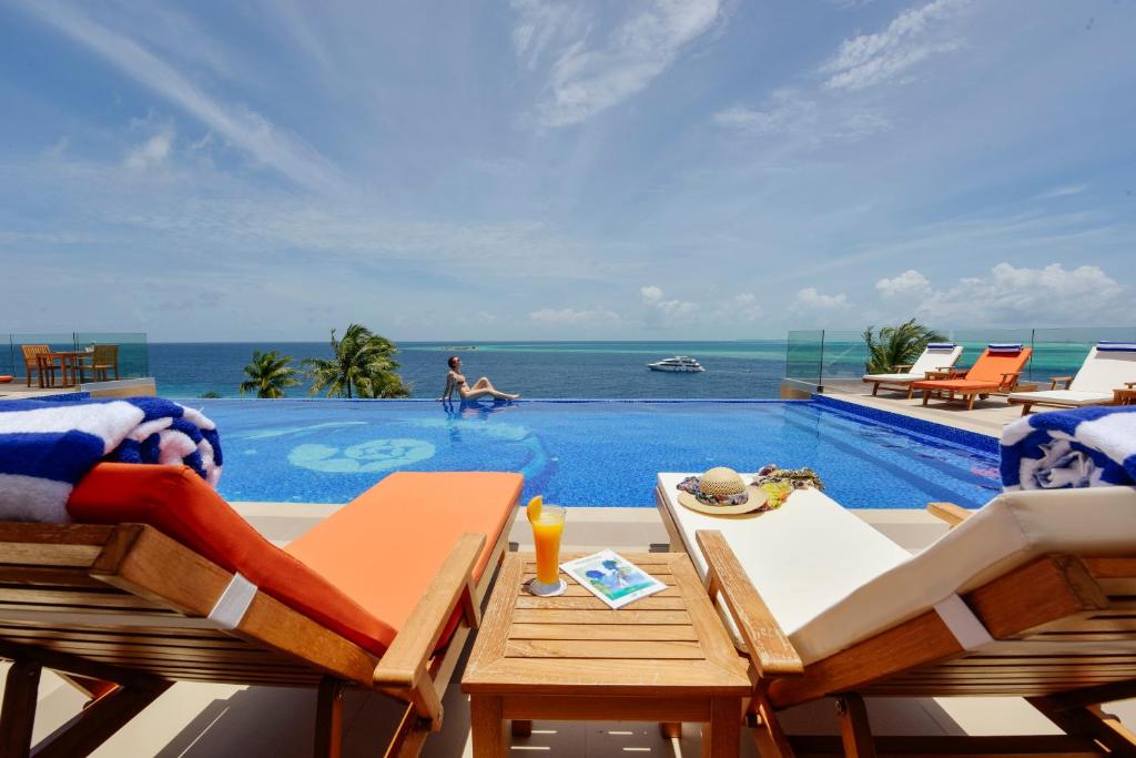 图鲁斯杜季节天堂酒店的一个带桌椅的海洋游泳池
