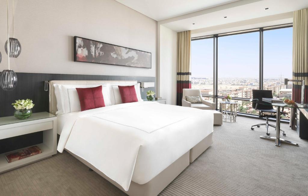 利雅德Fairmont Riyadh的卧室配有一张白色大床和一张书桌