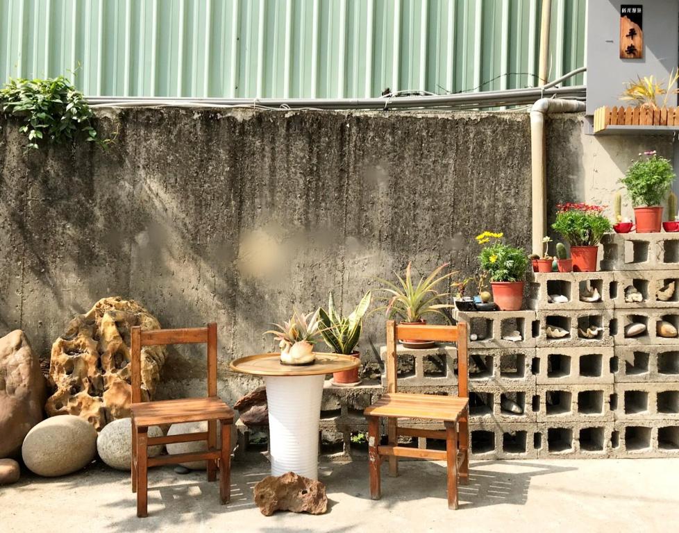 Ting-liao蒔光漫築民宿的庭院配有两把椅子和一张桌子,还有一些植物
