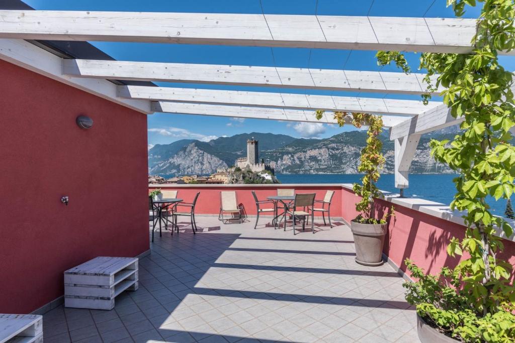 马尔切西内APPARTAMENTI Residence La Pergola的一个带桌椅的庭院,享有水景