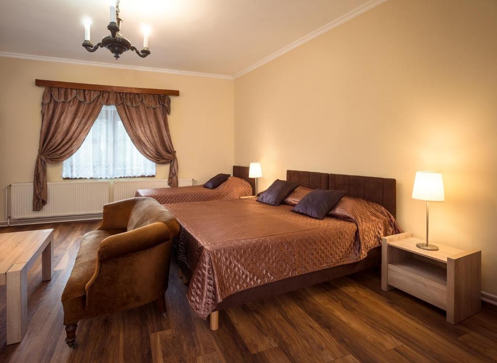 维谢格拉德Honti Apartmanház的卧室配有床、椅子和窗户。