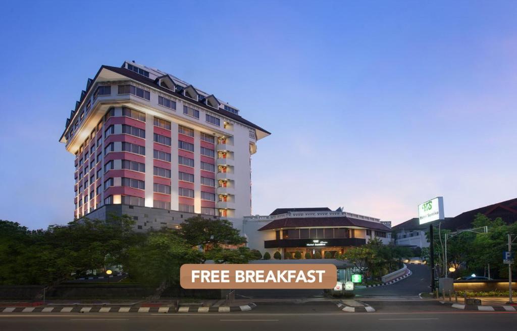 三宝垄桑提卡三宝垄酒店的一座大型建筑,前面有免费早餐标志