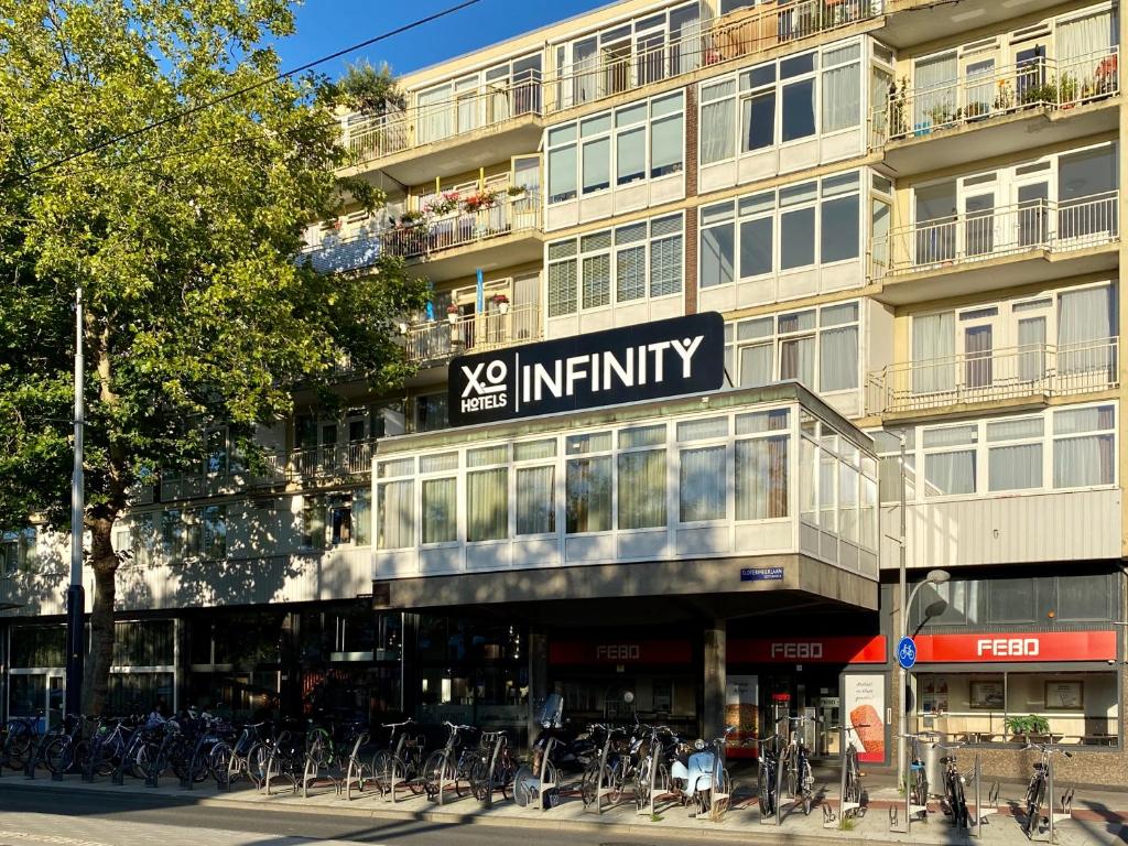 阿姆斯特丹XO Hotels Infinity的一座大型建筑,前面停放着自行车