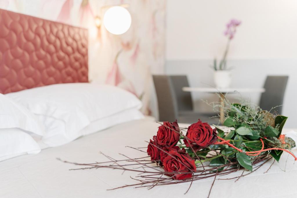 维罗纳Hotel Giulietta e Romeo ***S的床上一束红玫瑰