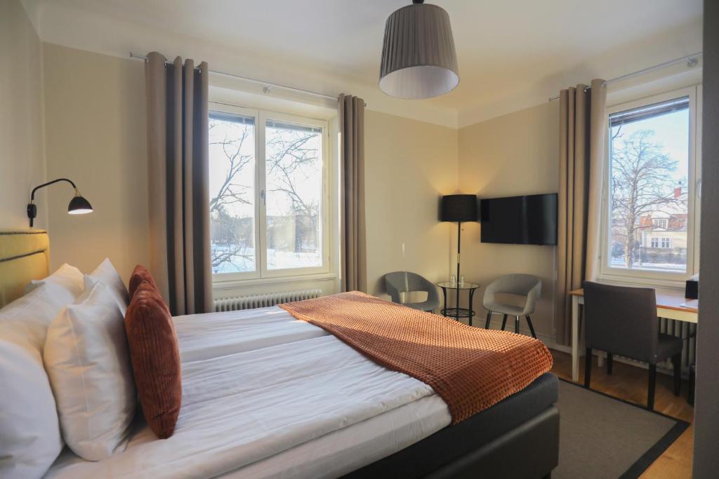 克里斯蒂娜港公园酒店的一间卧室配有一张带书桌的床和两个窗户。