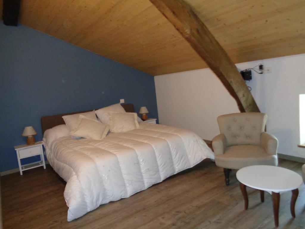 Saint-Sylvestre-sur-Lotlocation chambre d hotes clodeguy No 1的卧室配有白色的床和椅子