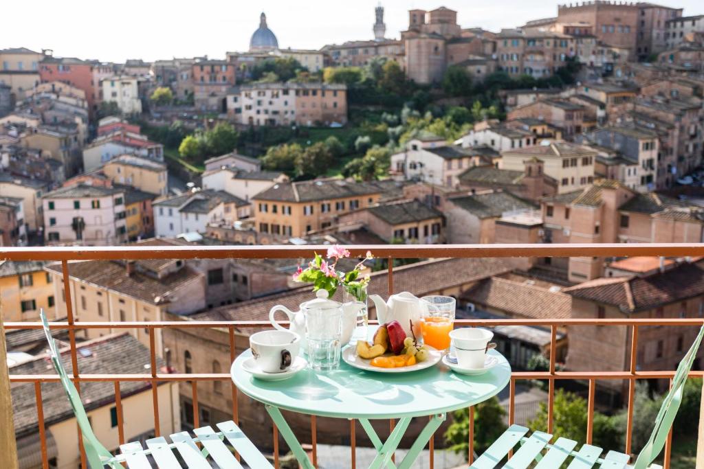锡耶纳密涅瓦酒店的阳台上的桌子上放着一盘食物和咖啡