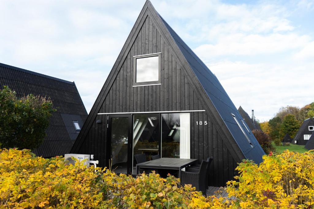 FarsøHimmerland Resort Cottages的黑房子,有 ⁇ 帽屋顶