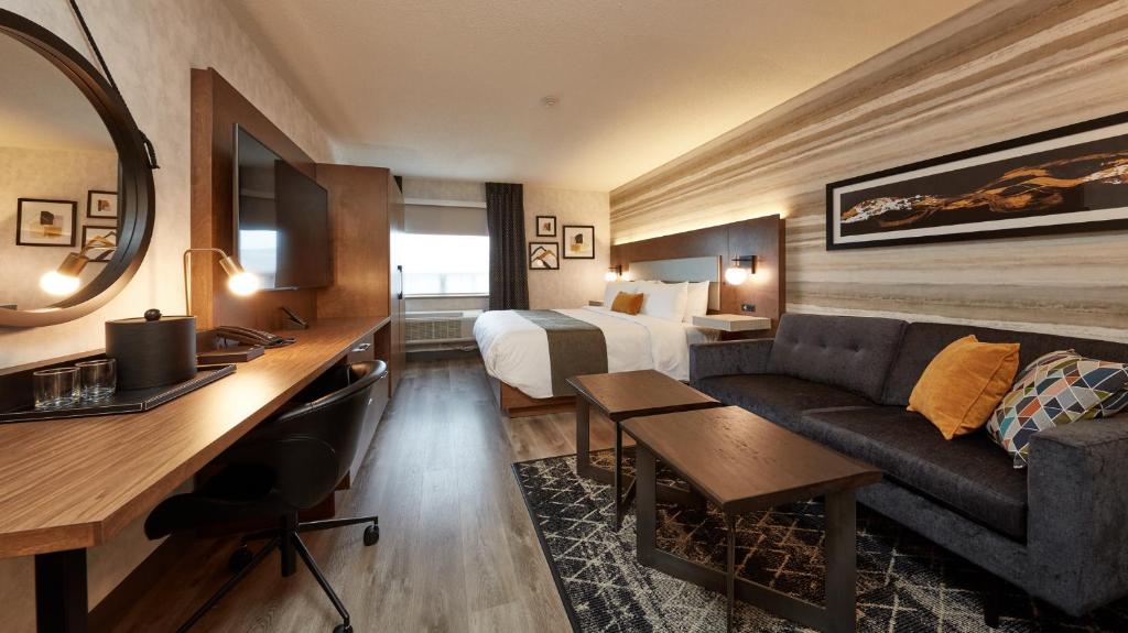 多伦多多伦多尚印酒店的酒店客房配有一张床、一张沙发和一张书桌。