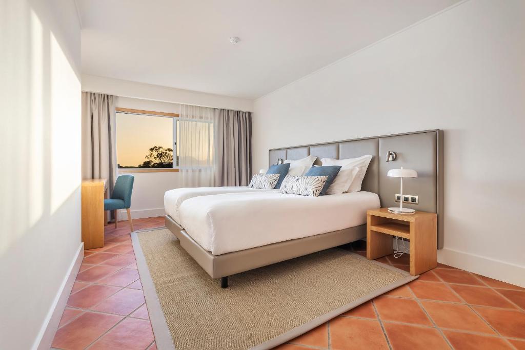 阿尔布费拉The Patio Suite Hotel的一间卧室配有一张床、一张桌子和一把椅子