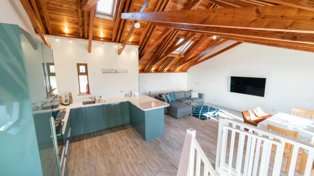 戈尔韦Stylish, Spacious Sea View House的厨房和客厅设有木制天花板。