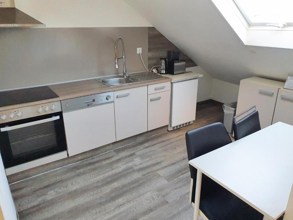 吕塞尔斯海姆FMI44Apartment的厨房配有白色橱柜、水槽和桌子