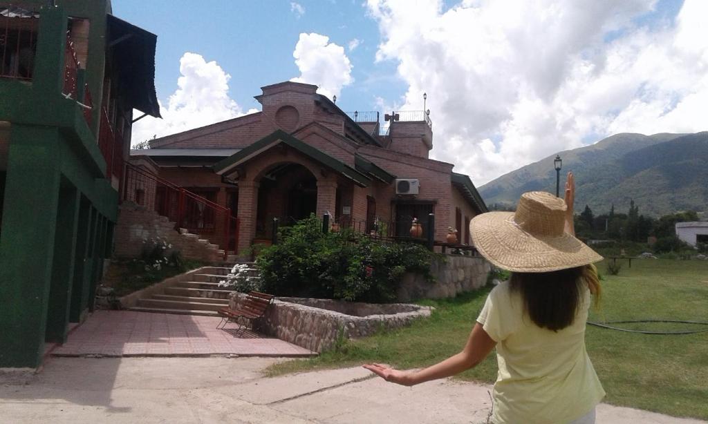 塔菲德尔瓦勒HOSTERIA BUENAVISTA的站在建筑物前身戴帽子的女人