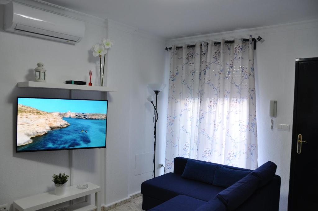 奇皮奥纳Villachipi的客厅设有蓝色的沙发和墙上的电视