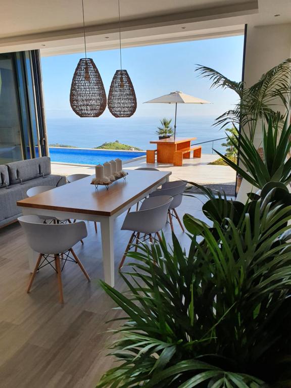 里韦拉布拉瓦Villa Brava Atlântico的一间带桌椅的海景用餐室