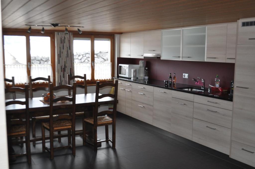 Aeschi bei SpiezRuhe pur的厨房配有白色橱柜和桌椅