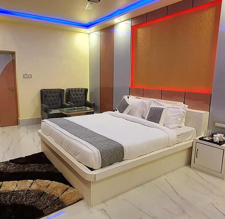 MadhubaniGokul Raj By WB Economy , Madhubani的一间卧室配有一张大床和一把椅子