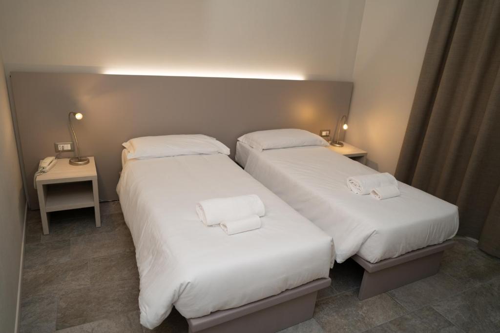 多索博诺欧罗巴酒店的配有白色床单的酒店客房内的两张床
