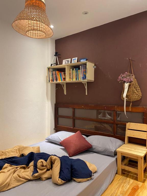 大叻Hostel-John Cafe and Beer的一间卧室设有一张床和一个书架