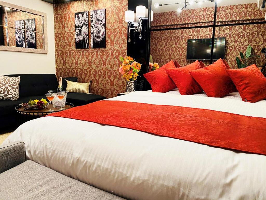 大阪@RLiS_house大阪ドームシティ的一间卧室配有一张带红色枕头的大床
