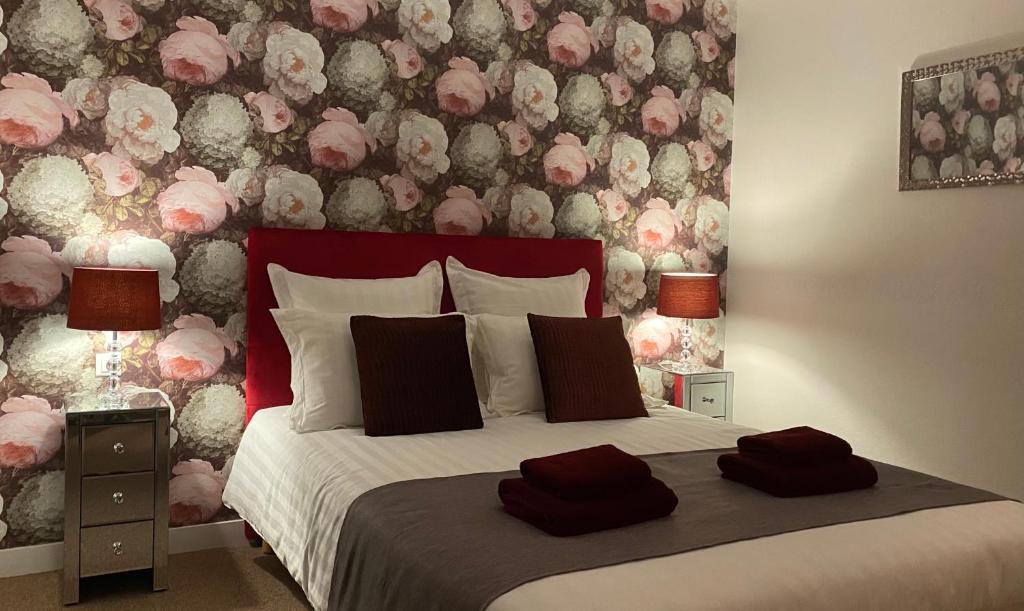 ÉvranLe Patio的一间卧室配有一张带花卉墙壁的床