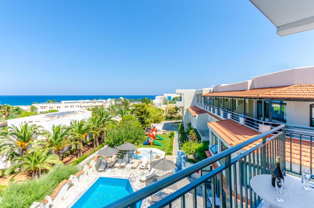 赫索尼索斯安娜玛丽亚村公寓的从度假村的阳台可欣赏到游泳池和海洋的景色