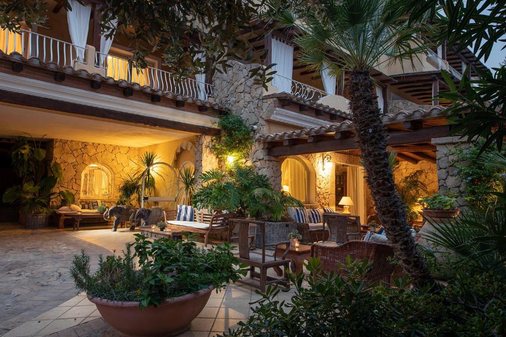 维拉西米乌斯苏瑟尔杰缇精品酒店的一座带椅子和棕榈树的建筑的庭院