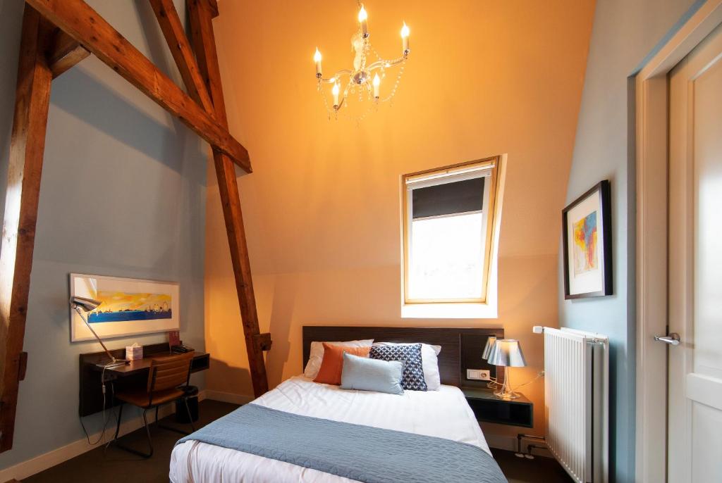 栋恩别墅酒店的一间卧室配有一张床和一个吊灯
