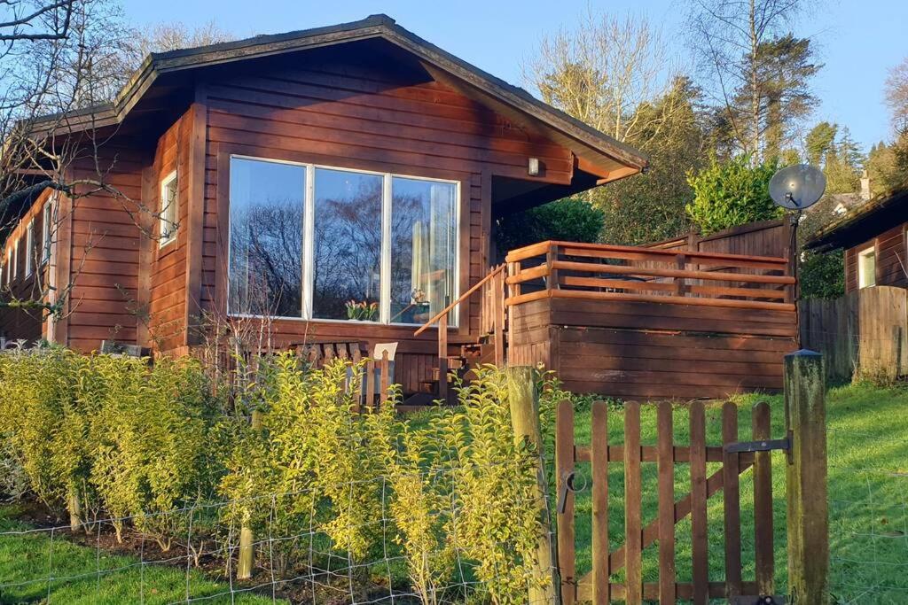 RudyardLuxurious lodge, Hot tub at Rudyard Lake, couples or small family的小木屋前方设有围栏