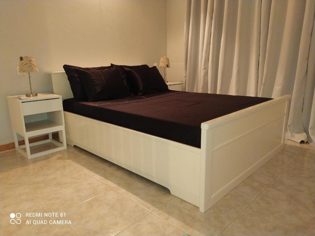 埃斯帕戈斯Apartamento Ferradura的卧室内的一张带黑色枕头的白色床