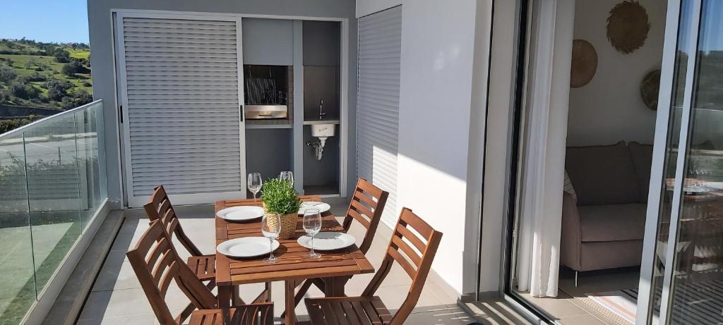 阿尔布费拉Albufeira beach apartment的阳台上的木桌和椅子