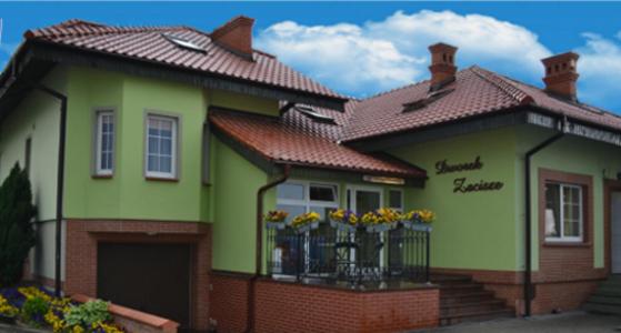 弗热希尼亚Dworek Zacisze的一座带鲜花的阳台小绿色房子