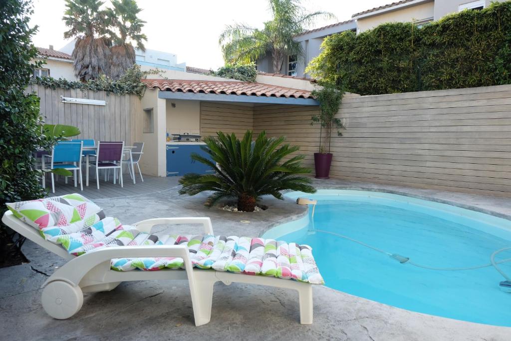 佩皮尼昂Très bel appartement (40m²) avec piscine privative的一座房子旁的游泳池,配有两把躺椅