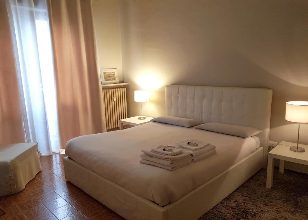 卡萨莱蒙费拉托Casa Moretti的一间卧室配有一张带两盏灯的大型白色床。