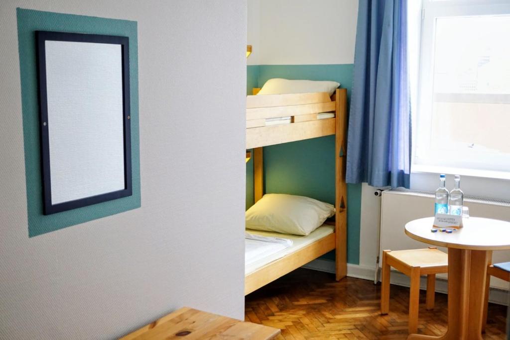 赫尔努姆何努青年旅舍的小房间设有双层床和桌子
