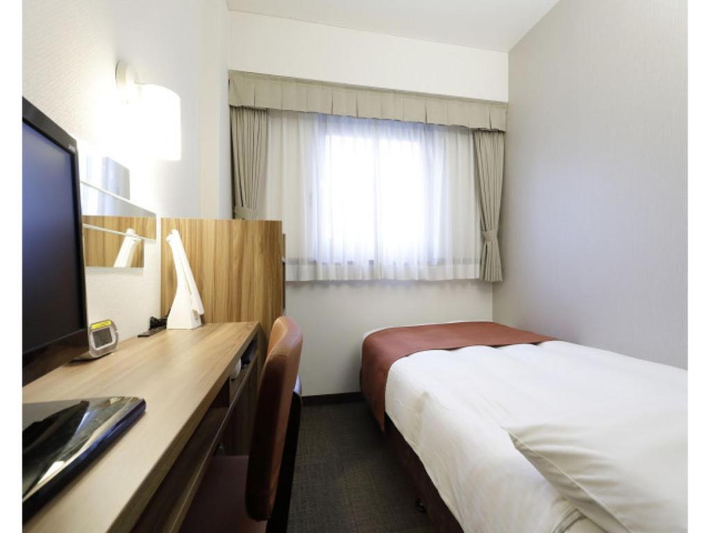 东京Tokyo Inn - Vacation STAY 10241v的酒店客房配有一张床和一张书桌及一台电视