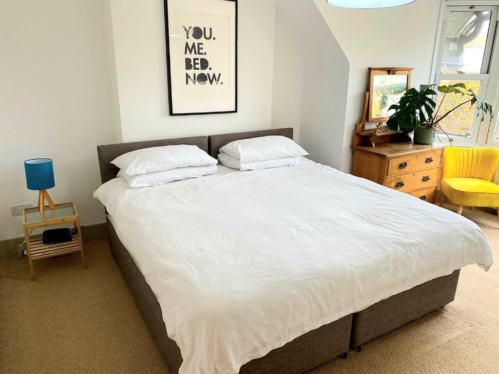 锡福德Upper Rooms Seaford的一间卧室配有一张带白色床单的大床