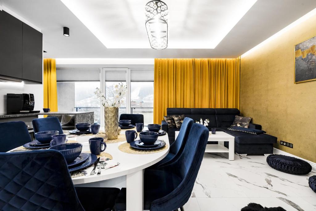 什切尔克Apartament Zacisze z prywatną sauną的一间带桌子和蓝色椅子的用餐室
